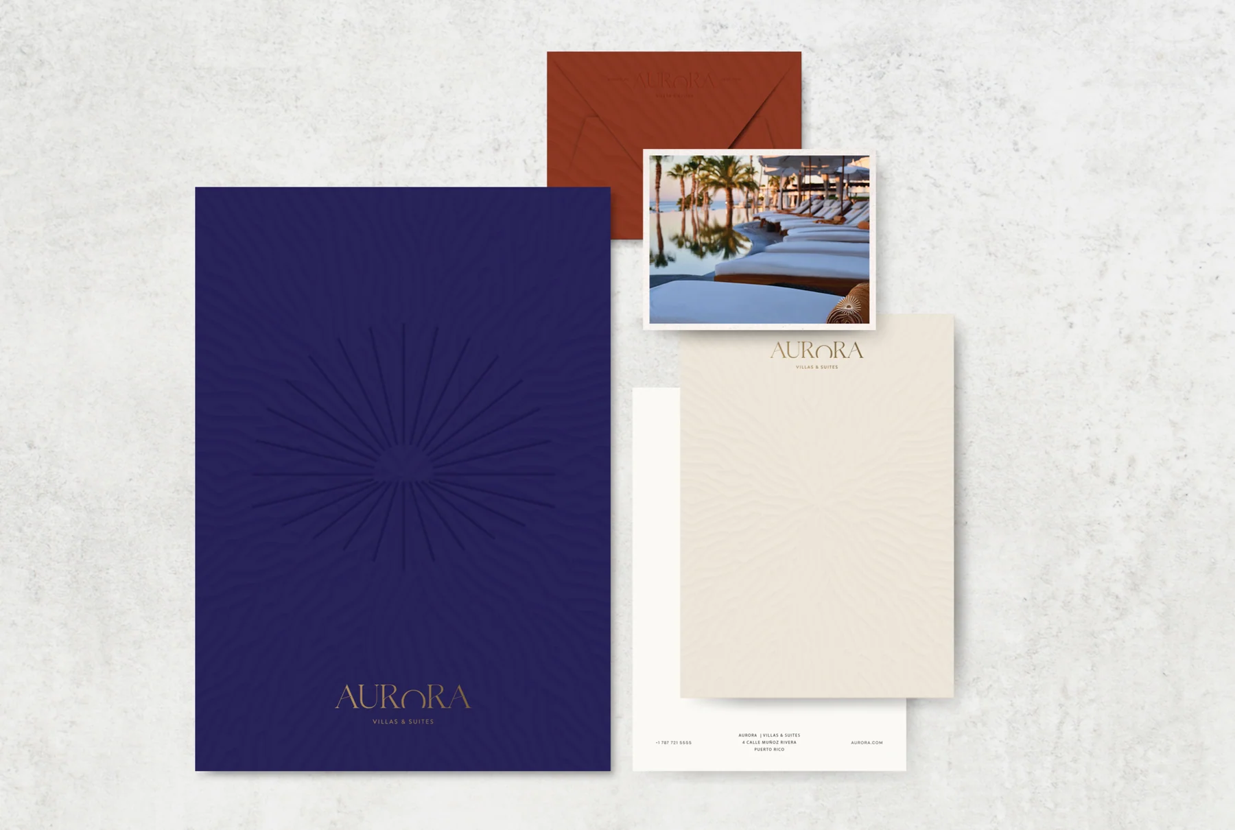Aurora stationery mockup with embossed sun patterns, purple and terracotta envelopes, and a photograph